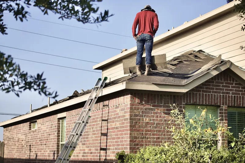 Professional roofer working on a residential roof in Snow Woods